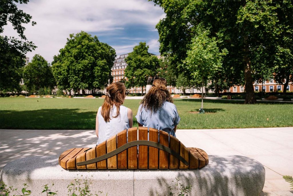 2 people sitting on a bench in grosvenor square